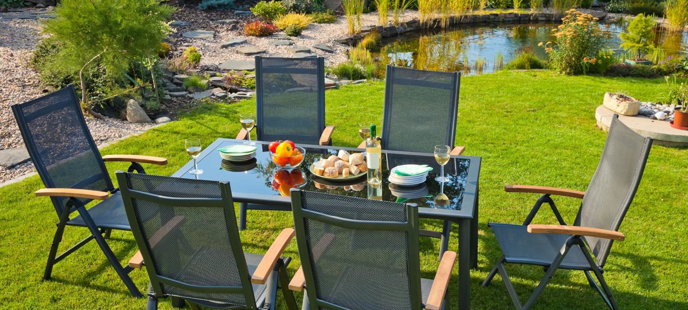 Un salon de jardin au soleil, entre pelouse et terrasse